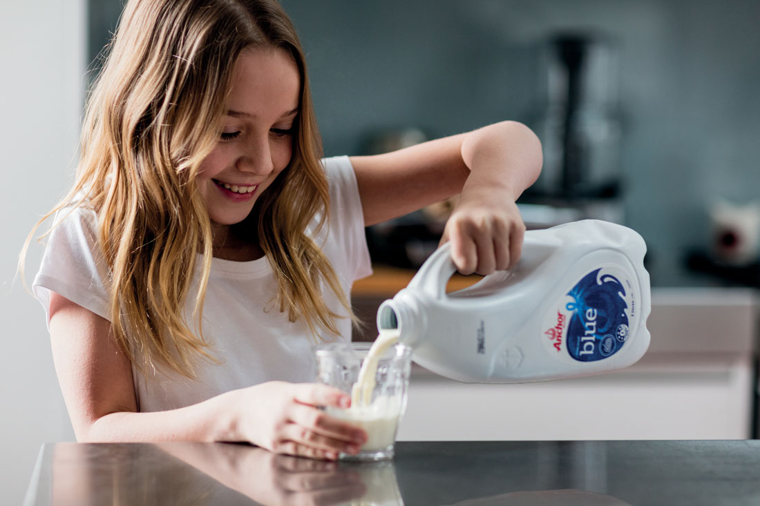 Girl pouring Anchor milk