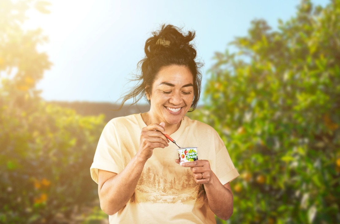 Woman enjoying a Fresh n Fruity yoghurt