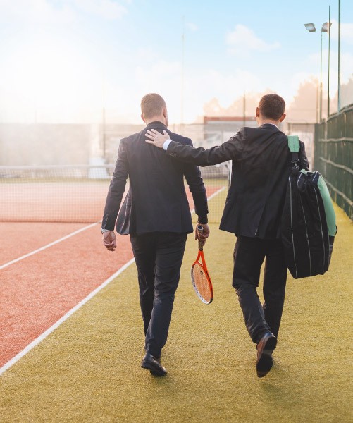 Men in suits at tennis court