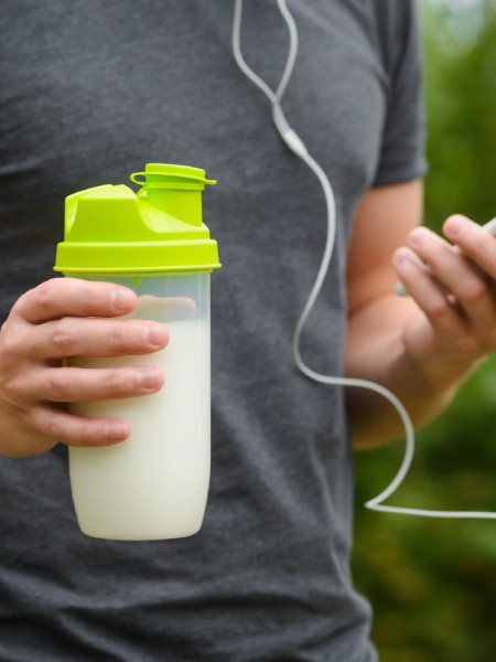 Male holding protein shake